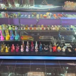 A bustling smoke shop environment displaying an assortment of items, from bongs to cigars and tobacco, arranged for easy browsing.