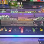 A bustling smoke shop environment displaying an assortment of items, from bongs to cigars and tobacco, arranged for easy browsing.
